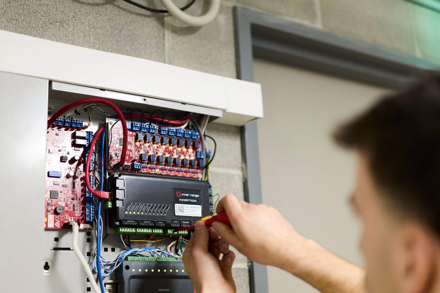 CED Security technician wiring an alarm panel