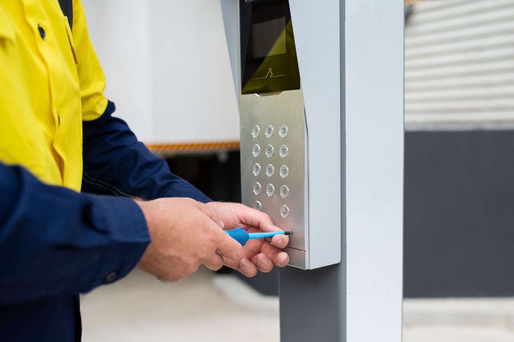 CED Security technician installing an intercom keypad on a bollard